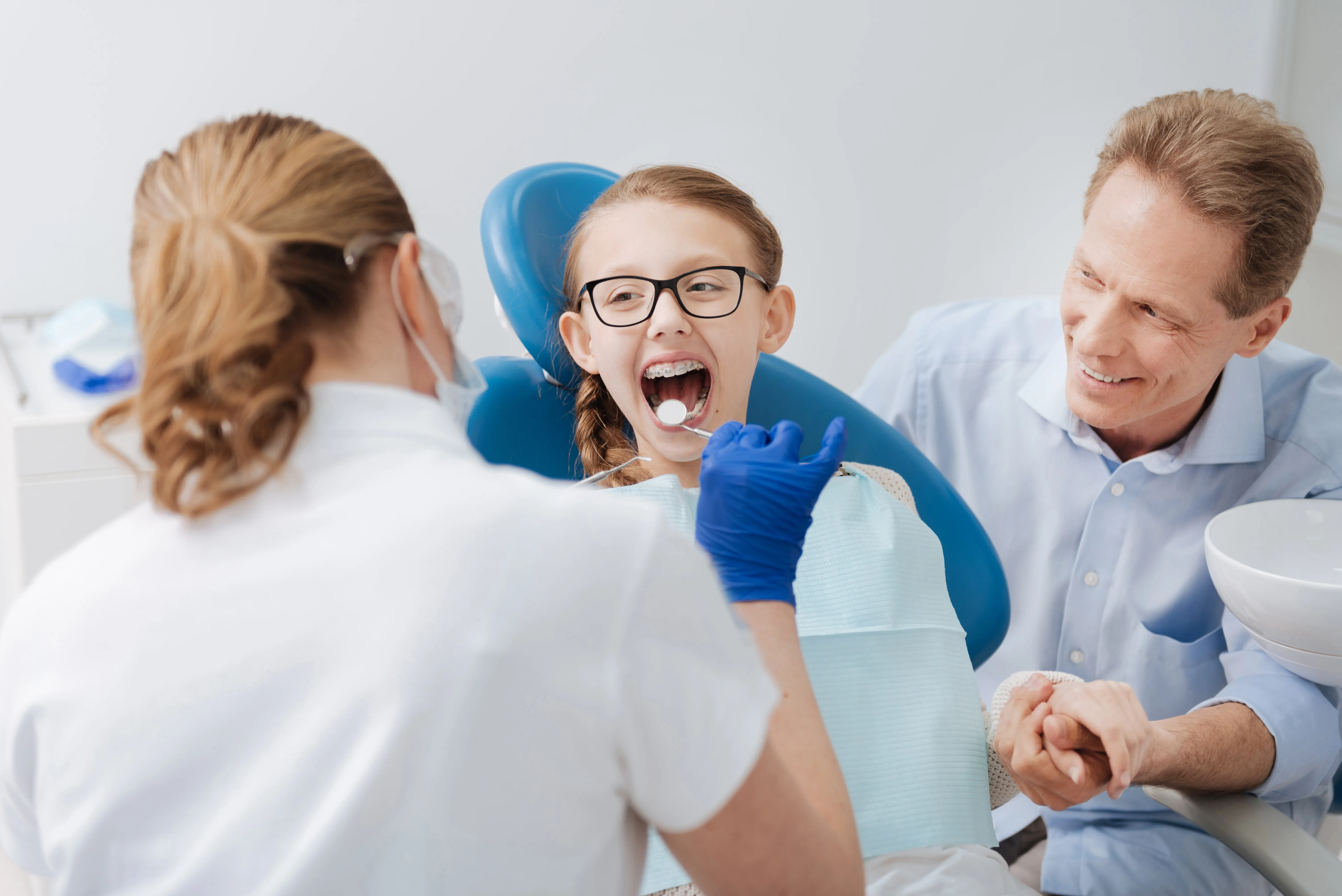 girl visiting dentist with her dad
